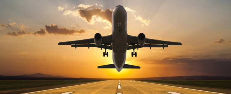 Passenger jet airplane taking off at sunset